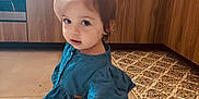 Lily-Rose participe au concours pour gagner de l'argent avec cette photo : toddler, child, blue_dress, ponytail, pacifier_clip, kitchen, floor, tile_floor, wooden_cabinets, patterned_rug, indoor, young_child, cute, sitting, playful, baby, person, hair, small_child, curious