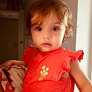 Lily-Rose participe au concours pour gagner de l'argent avec cette photo : toddler, child, face, portrait, indoor, orange_clothing, curly_hair, big_eyes, cute, person, soft_light, strawberry_print, short_sleeves, young_child, human, baby, looking_at_camera, casual, curiosity, close_up