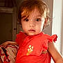 toddler, child, face, portrait, indoor, orange_clothing, curly_hair, big_eyes, cute, person, soft_light, strawberry_print, short_sleeves, young_child, human, baby, looking_at_camera, casual, curiosity, close_up