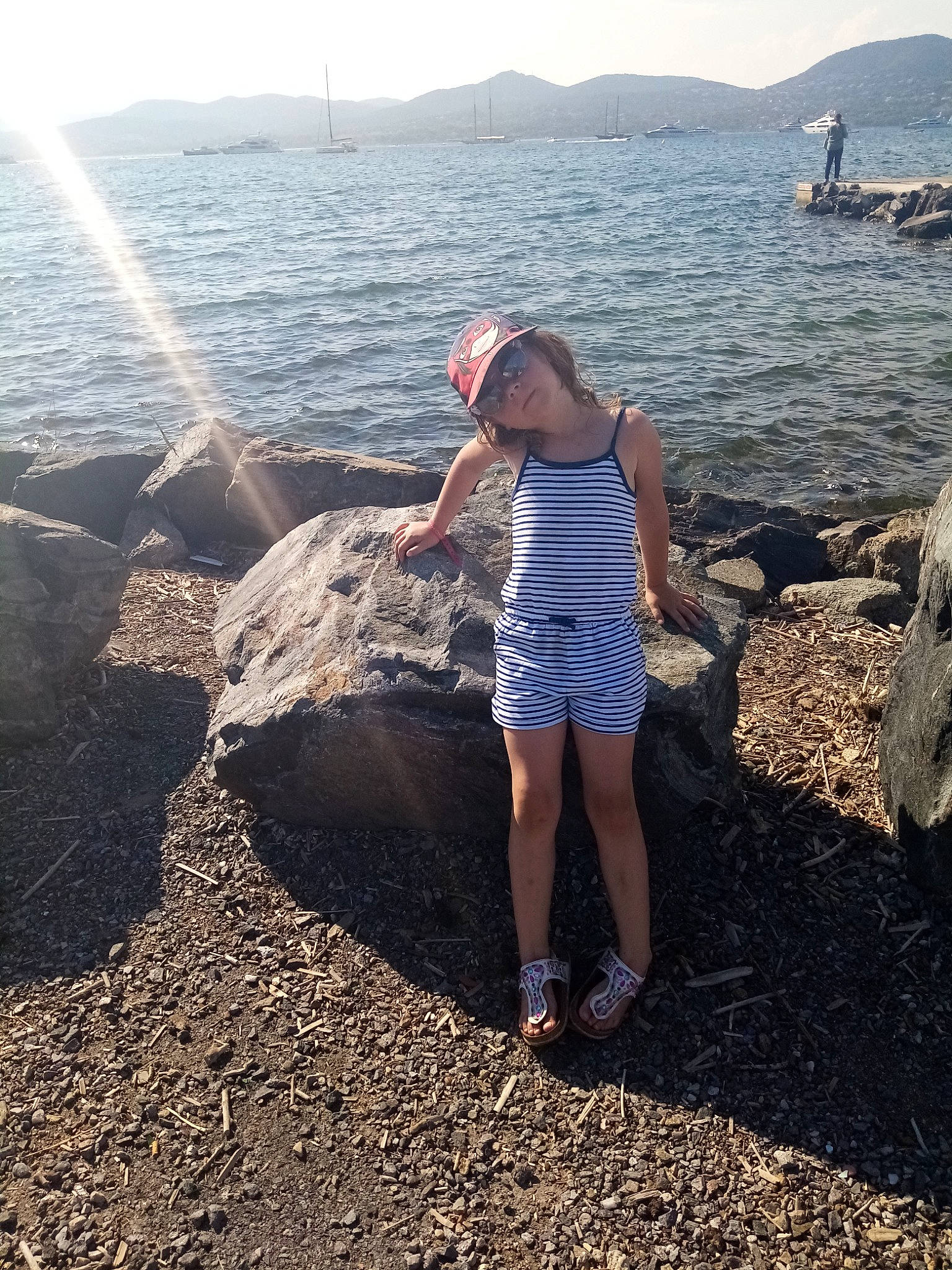 Louane a rejoint le concours — aidez-le/la à gagner de superbes lots ! azure, beach, coastal_and_oceanic_landforms, fun, happy, headland, headwear, horizon, lake, landscape, leg, leisure, morning, people_in_nature, person, sky, t_shirt, thigh, travel, water