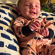 Avery joined the competition — help win amazing prizes! baby, infant, smiling, cushion, whale_pattern, onesie, peach_color, black_prints, hand, face, happy, cute, indoor, child, portrait, cozy, fabric, pattern, person, young