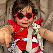 Charlotte joined the competition — help win amazing prizes! toddler, child, sunglasses, red_clothing, stroller, toy, giraffe_toy, seatbelt, baby, cute, smile, reaching_hand, infant, outdoor, sun_protection, accessory, white_shorts, playful, closeup, portrait