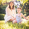 child, toddler, woman, grass, outdoor, sunlight, nature, greenery, overalls, lace_dress, portrait, daylight, curious, baby, kneeling, summer, family, park, people, tree_leaves