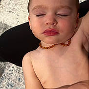 Itai is registered to the contest to win money with this photo: toddler, child, sleeping, necklace, diaper, skin, peaceful, resting, baby, indoors, portrait, closeup, face, arm, bare_chest, relaxation, soft_light, texture, background, comfort