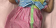 Kulture is registered to the contest to win money with this photo: baby, child, smiling, laughing, striped_dress, headband, bow, colorful_clothing, socks, lying_down, pink_background, happy, cute, infant, portrait, indoors, cheerful, fashion, accessory, skin