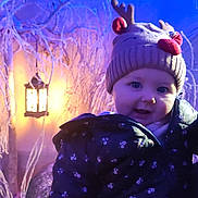 Louise participe au concours pour gagner de l'argent avec cette photo : baby, blue_light, child, cozy, cute, festive, frosty_branches, glow, hat, holiday, indoors, jacket, lantern, light, orange_light, portrait, reindeer_hat, smiling, winter, winter_clothing