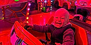 Stanislas participe au concours pour gagner de l'argent avec cette photo : amusement_park, carnival, child, clothing, colorful, evening, excited, face, fun, happy, jacket, lights, outdoor, playful, ride, seat, smiling, toddler, toy_car, vehicle