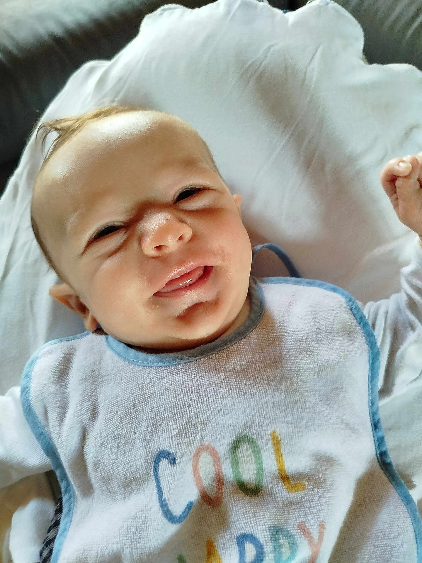 Milo a rejoint le concours — aidez-le/la à gagner de superbes lots ! baby, infant, smiling, bib, clothing, face, head, lying_down, blanket, happy, cute, skin, tongue, indoors, person, young_child, portrait, expression, comfort, soft