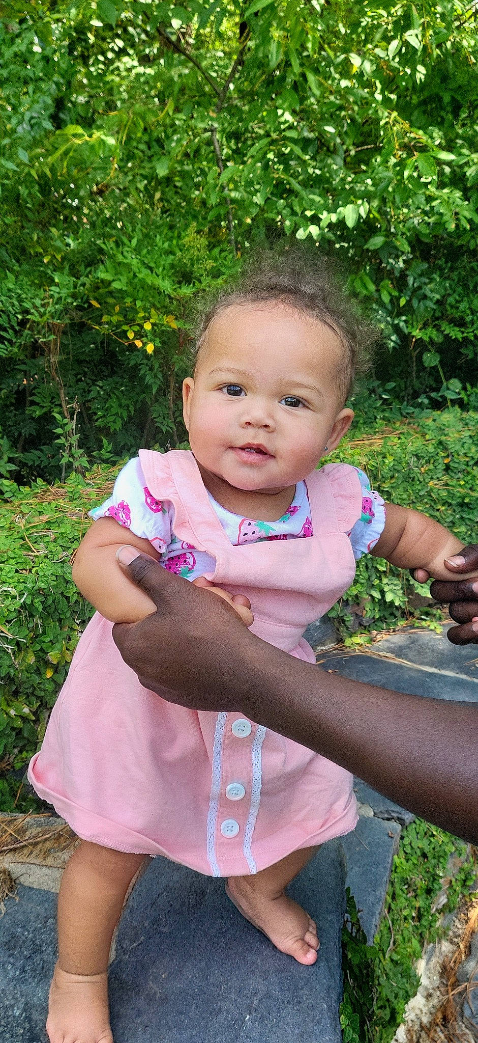 Araith Leight Stone is registered to the contest to win money with this photo: arm, baby, baby_toddler_clothing, botany, eye, face, gesture, grass, hairstyle, hand, happy, iris, leaf, lip, nose, people_in_nature, person, pink, plant, skin