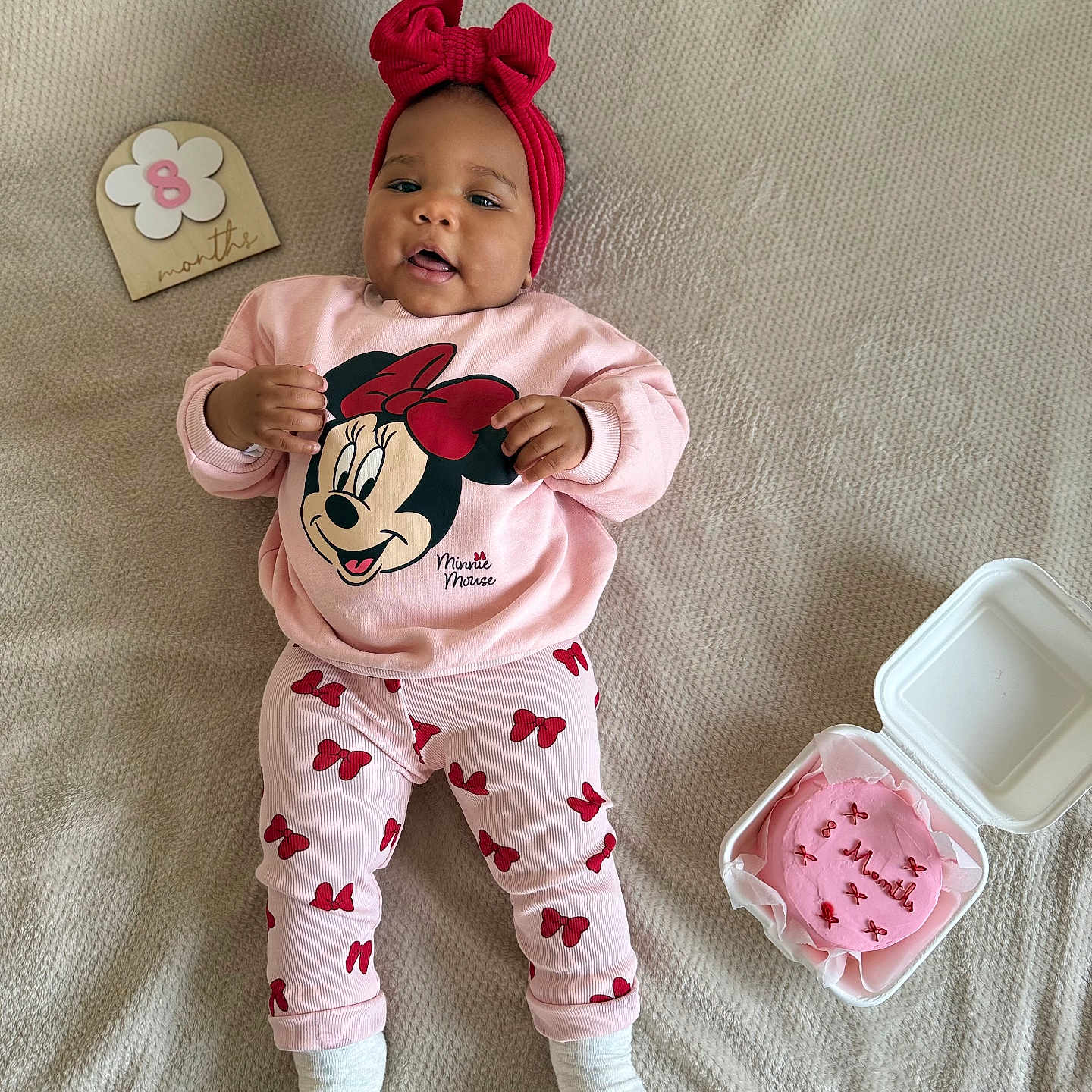 Ellyne a rejoint le concours — aidez-le/la à gagner de superbes lots ! 8_months, baby, blanket, cake, celebration, child, clothing, cute, happy, headband, indoor, infant, lying_down, milestone, pajamas, person, pink, portrait, red_bow, smiling