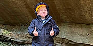Asher James K Sabat is registered to the contest to win money with this photo: bodypart, boy, cap, child, clothing, coat, face, hat, head, hood, jacket, jeans, male, pants, person, photography, portrait, rock, soil, standing