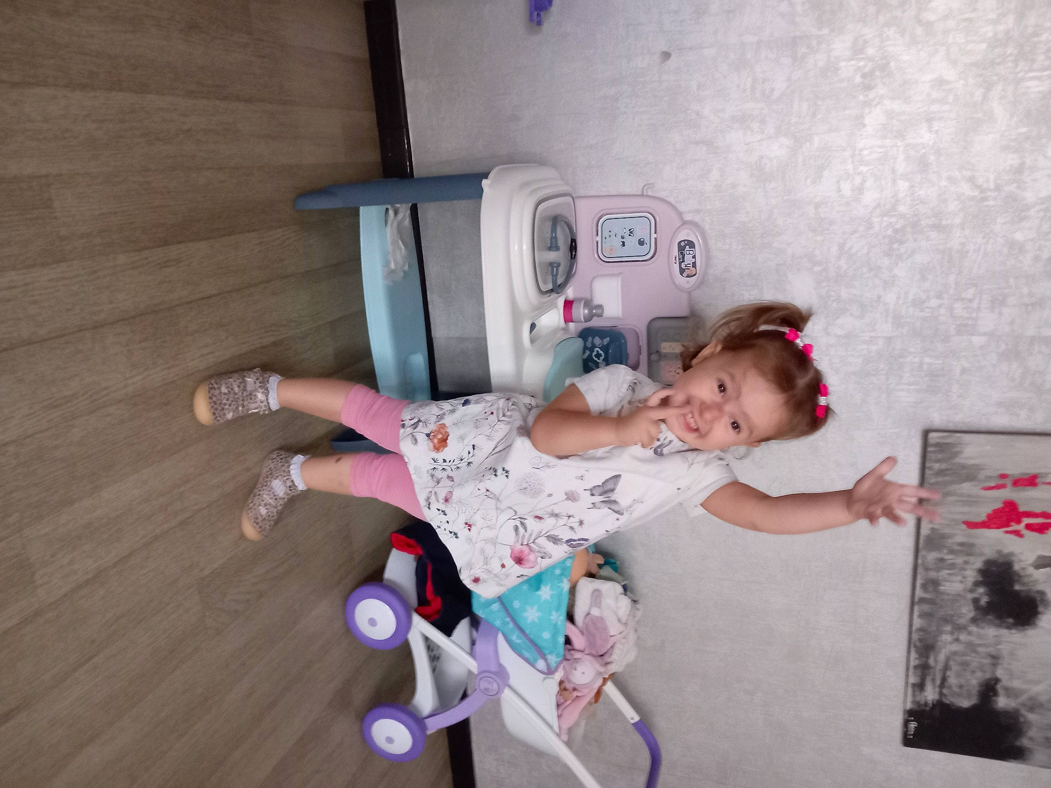 Azalyne participe au concours pour gagner de l'argent avec cette photo : baby, baby_toddler_clothing, child, flooring, fun, happy, hardwood, joy, leg, person, room, sandal, sitting, smile, sock, table, toddler, wood