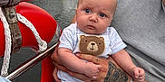 Jenson joined the competition — help win amazing prizes! baby, infant, person, tattoo, hand, boat, water, lake, sailboat, life_buoy, clothing, expression, outdoor, adult, bracelet, nature, sky, trees, face, holding