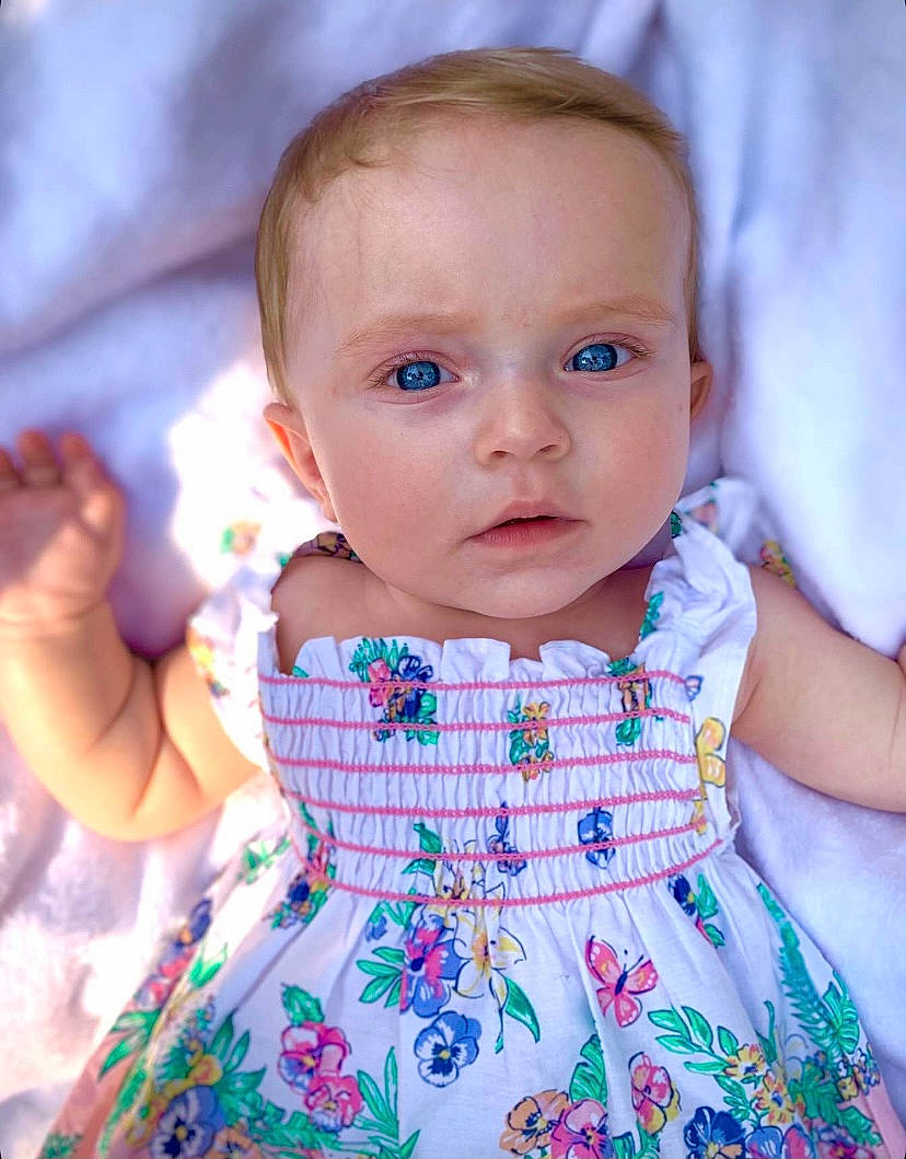 Timber is registered to the contest to win money with this photo: arm, azure, baby_toddler_clothing, cheek, chin, dress, face, finger, hairstyle, hand, happy, head, iris, lip, neck, one_piece_garment, person, pink, shoulder, skin