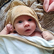 Ethan participe au concours pour gagner de l'argent avec cette photo : baby, blanket, child, cozy, curious, cute, expression, eyes, face, hands, hooded_towel, indoor, infant, newborn, person, portrait, skin, soft_texture, warm, wrapped