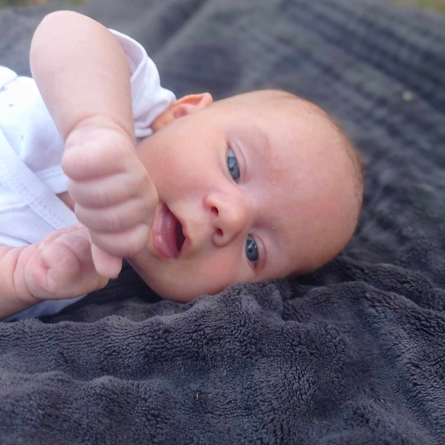 Lyam participe au concours pour gagner de l'argent avec cette photo : baby, blanket, blue_eyes, casual_clothing, child, closeup, curious, expression, face, hand, infant, lying_down, natural_light, newborn, outdoor, person, photography, resting, skin, soft_texture