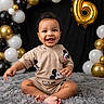 baby, child, smiling, sitting, mickey_mouse, balloons, birthday, gold_balloon, black_balloon, white_balloon, fluffy_rug, cute_clothing, happy, portrait, indoor, celebration, number_6, curly_hair, infant, young_child