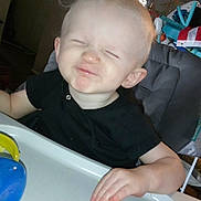 Jacob joined the competition — help win amazing prizes! toddler, child, high_chair, black_shirt, toy, indoor, face, expression, hand, blond_hair, table, plastic, furniture, baby, smiling, squinting, person, home, play, cute