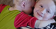 Austin joined the competition — help win amazing prizes! child, children, hug, floor, wood_floor, smile, striped_shirt, red_sleeves, green_shirt, blond_hair, happy, cute, toddler, sibling, indoor, portrait, playful, affection, casual_clothing, baby