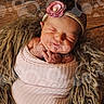 Delilah joined the competition — help win amazing prizes! newborn, baby, sleeping, wrapped, pink, blanket, headband, flower, fur_texture, wooden_background, portrait, infant, cute, peaceful, studio_watermark, closeup, soft_lighting, cozy, resting, child