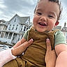 toddler, child, smile, happy, curly_hair, hands, overalls, corduroy, outdoor, house, cloudy_sky, person, skin, portrait, baby, green_shirt, nails, holding, cute, expression