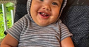 Albin joined the competition — help win amazing prizes! baby, child, curly_hair, cute, expression, face, greenery, happy, high_chair, hoodie, indoor, orange_blinds, person, portrait, seated, smiling, striped_clothing, toddler, window, young_child