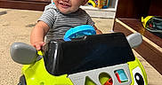 Albin joined the competition — help win amazing prizes! child, clothing, colorful, curly_hair, cute, expression, floor, furniture, happy_face, indoor, person, plastic, playing, playroom, shelf, smiling, toddler, toy, toy_car, young_child