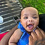 Kiara joined the competition — help win amazing prizes! baby, child, smiling, laughing, blue_clothing, tattoo, hand, arm, bench, outdoor, grass, phone, person, happy, portrait, infant, skin, cute, daylight, holding