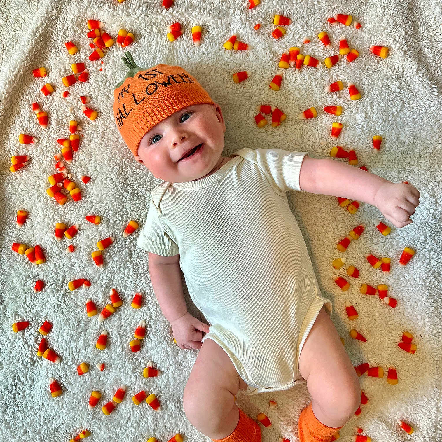 Landon is registered to the contest to win money with this photo: baby, beanie, blanket, cap, clothing, face, flower, happy, hat, head, hosiery, newborn, person, petal, photography, plant, portrait, sitting, smile, sock