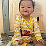 baby, child, smiling, sitting, pajamas, yellow_stripes, playpen, play_mat, indoor, cute, happy, infant, foot, hand, face, head, person, toddler, clothing, toy