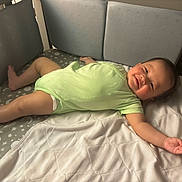 Haysen is registered to the contest to win money with this photo: baby, smiling, onesie, lying_down, infant, cheeks, mattress, quilt, bed, sleeping_area, comfort, happy, child, indoor, padded, fabric, soft, cute, skin, person