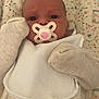Halo is registered to the contest to win money with this photo: baby, infant, pacifier, mittens, bib, winnie_the_pooh, clothing, blanket, floral_pattern, cute, lying_down, newborn, child, face, expression, indoors, soft_lighting, sleepwear, comfort, adorable