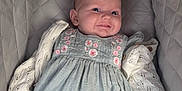 Halo is registered to the contest to win money with this photo: baby, infant, smile, dress, knitted_sweater, beaded_clip, seat, cushion, comfort, portrait, cute, child, young, happy, face, eyes, clothing, fabric, indoor, person