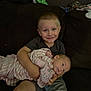 Daniel is registered to the contest to win money with this photo: child, baby, smiling, holding, couch, blanket, indoor, family, portrait, happy, seated, clothing, young, toddler, infant, sibling, cute, casual, cozy, relaxed