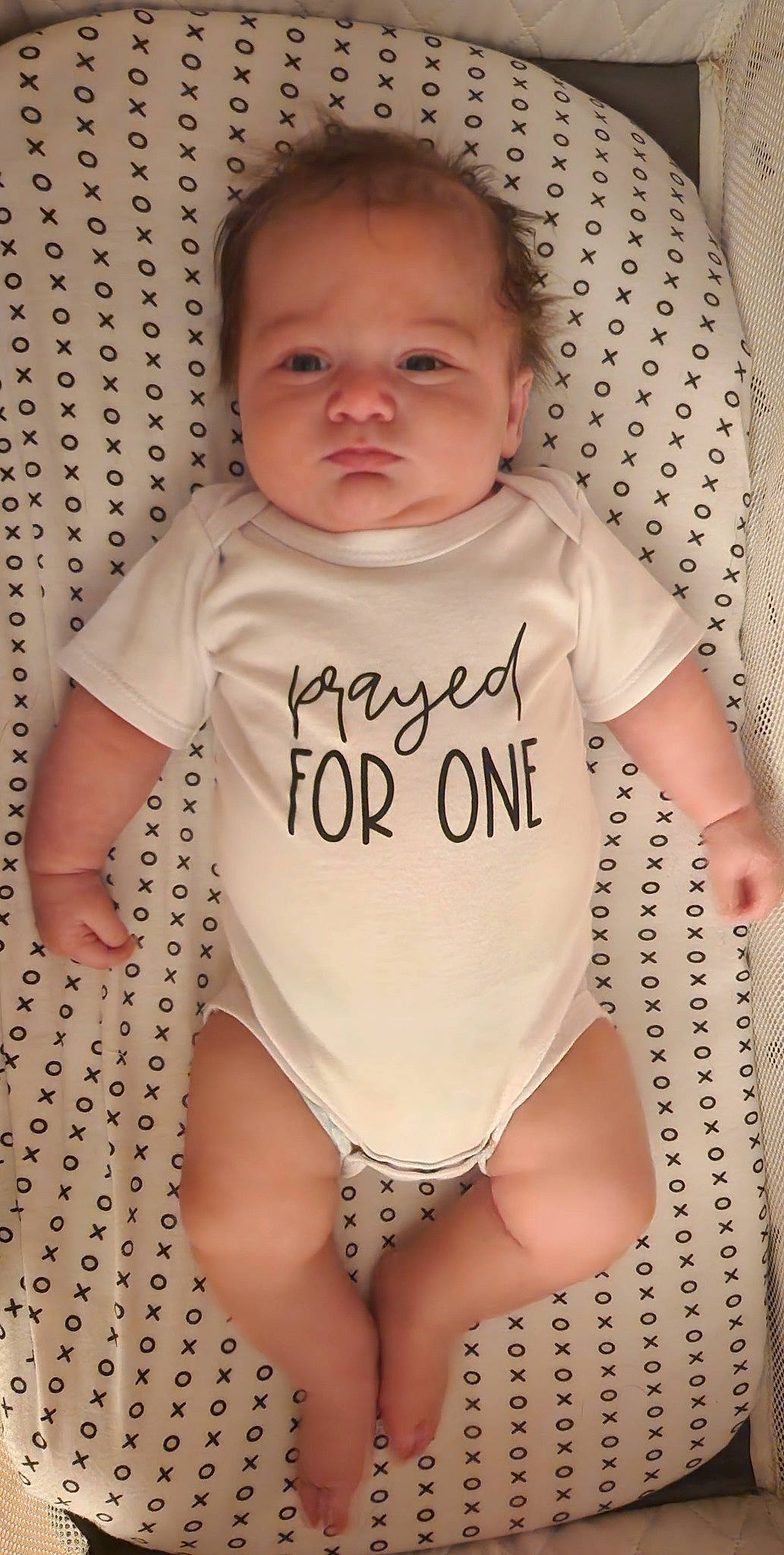 John is registered to the contest to win money with this photo: arm, baby, baby_toddler_clothing, cheek, eye, face, finger, hair, head, human_body, infant_bodysuit, jeans, joint, neck, one_piece_swimsuit, outerwear, person, skin, sleeve, stomach