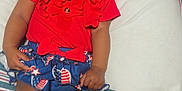 Jamoni joined the competition — help win amazing prizes! baby, smiling, red_clothing, blue_skirt, white_socks, blanket, striped_blanket, infant, happy, cute, sitting, indoors, child, person, face, head, legs, hand, comfort, portrait