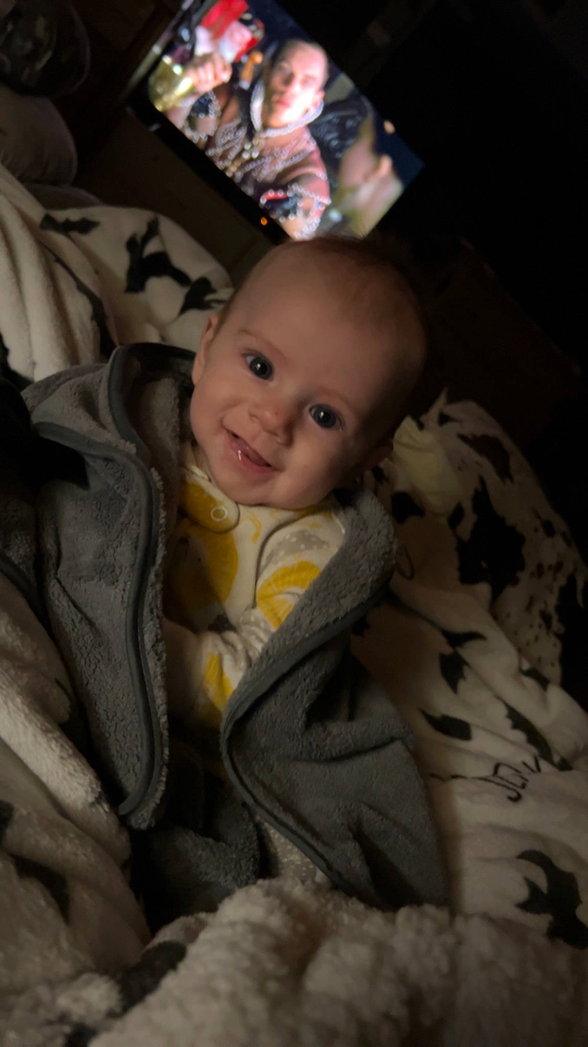 Brooks is registered to the contest to win money with this photo: baby, baby_products, baby_toddler_clothing, brown, cheek, child, comfort, darkness, fun, fur, iris, linens, person, room, sitting, sleeve, smile, textile, toddler, wood