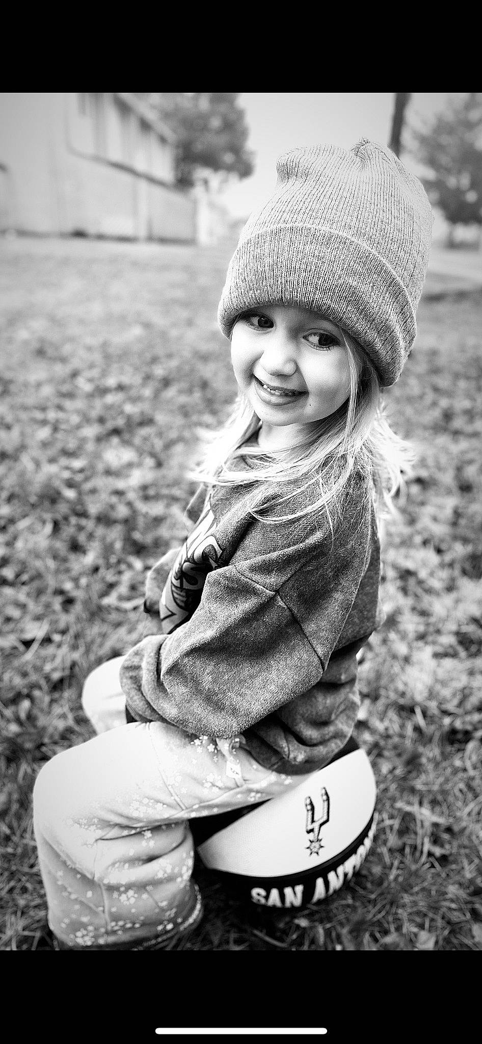 Olive is registered to the contest to win money with this photo: black, black_and_white, clothing, eye, face, facial_expression, flash_photography, grass, happy, head, headgear, headwear, joy, lip, organ, people_in_nature, person, photograph, plant, smile