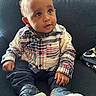 baby, child, infant, portrait, sitting, couch, indoor, plaid_shirt, shirt, pants, sneakers, shoes, face, eyes, hair, curious, looking_up, hands, furniture, photography