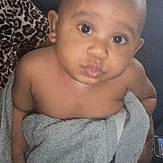 Bryson joined the competition — help win amazing prizes! baby, infant, child, portrait, face, eyes, looking_at_camera, serious_expression, bare_shoulders, towel, gray_towel, wrapped, sitting, cushion, leopard_print, indoors, close_up, soft_lighting, photography, safe