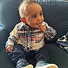 Bryson is registered to the contest to win money with this photo: baby, child, infant, smiling, sitting, portrait, indoor, couch, plaid_shirt, pants, sneakers, fashion, face, eyes, hair, hand, home, furniture, window, daylight