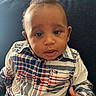 Bryson is registered to the contest to win money with this photo: baby, child, infant, portrait, sitting, couch, plaid_shirt, clothing, thumbs_up, face, eyes, hair, smiling, indoors, home, furniture, close_up, photography, adorable, casual