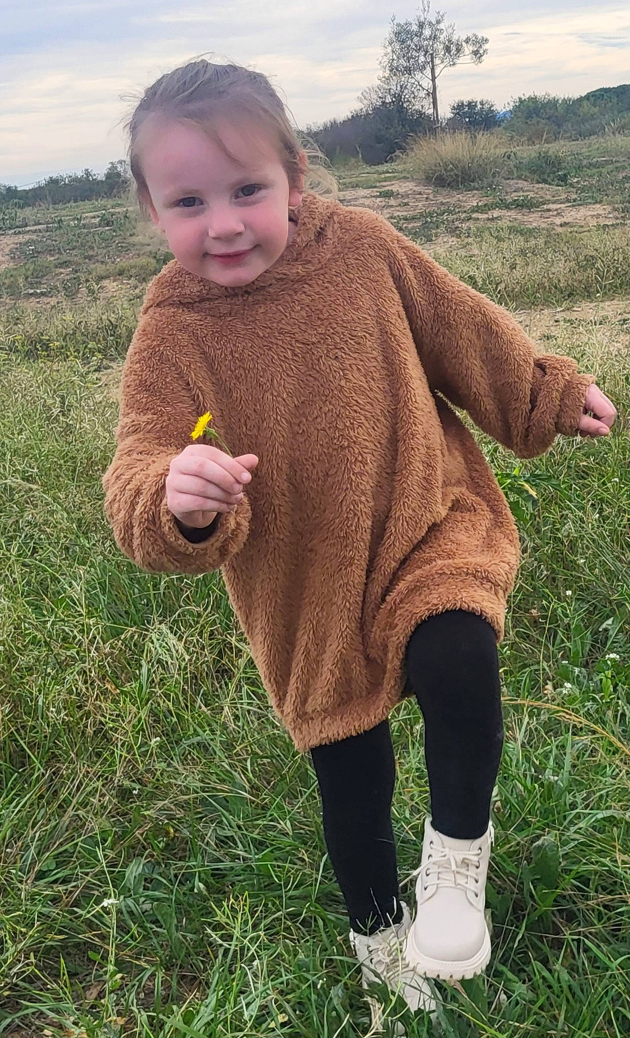 Lyla participe au concours pour gagner de l'argent avec cette photo : baby_toddler_clothing, gesture, grass, grassland, hand, happy, joy, landscape, meadow, pattern, people_in_nature, person, plant, prairie, sky, sleeve, smile, soil, thumb, toddler