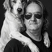 Philou participe au concours pour gagner de l'argent avec cette photo : adult, black_and_white, black_shirt, close_up, companionship, dark_background, dog, dramatic_lighting, floppy_ears, golden_retriever, long_hair, owner, paws, person, pet, portrait, shoulder, studio, sunglasses, white_fur
