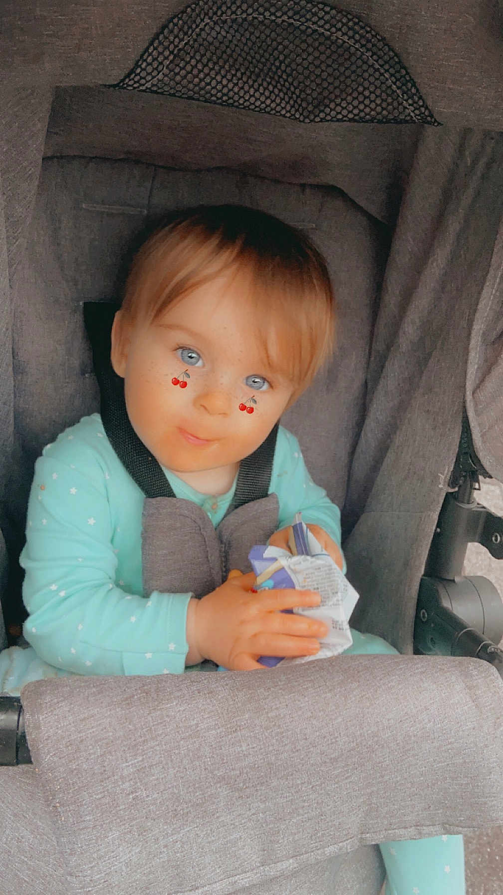 Bailey joined the competition — help win amazing prizes! toddler, child, stroller, baby, blue_eyes, cherry_sticker, onesie, mint_green, hand, face, seatbelt, snack_wrapper, gray_fabric, cute, indoor, portrait, young_child, sitting, infant, expression