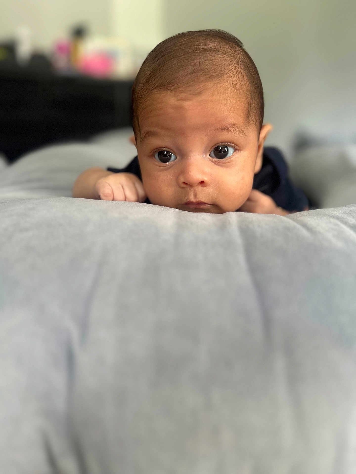 Matthew joined the competition — help win amazing prizes! baby, infant, face, eyes, hands, pillow, soft_surface, curious, lying_down, indoors, portrait, child, skin, closeup, head, expression, young, person, sleepwear, focus