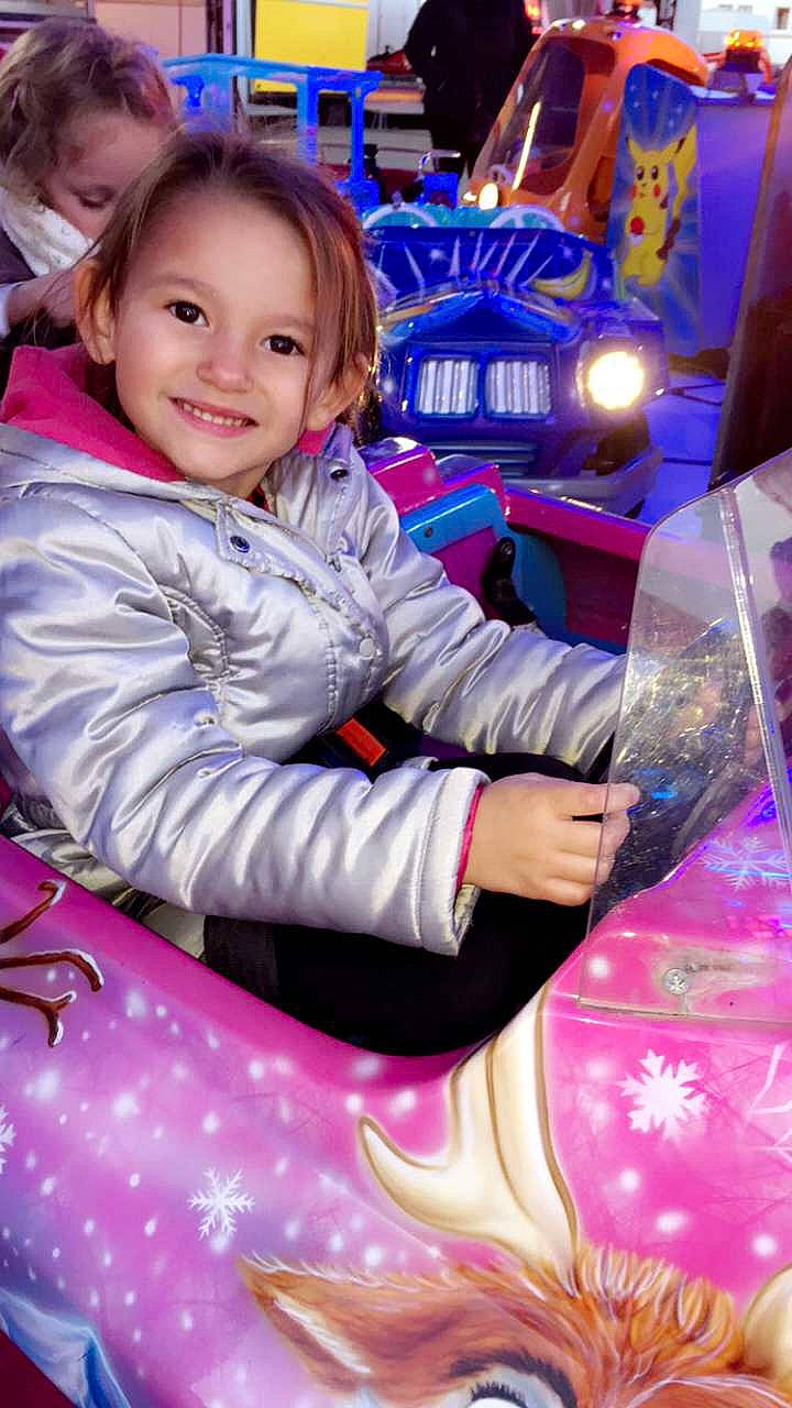 Kayla participe au concours pour gagner de l'argent avec cette photo : amusement_park, amusement_ride, child, fun, girl, joy, person, product, purple, recreation, smile, toddler