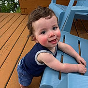 Leon joined the competition — help win amazing prizes! toddler, child, smiling, happy, outdoor, deck, wood, blue_chair, barefoot, curly_hair, face, person, summer, playful, leaning, clothing, tank_top, shorts, daylight, nature
