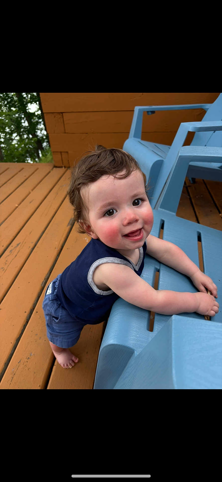 Leon joined the competition — help win amazing prizes! toddler, child, smiling, happy, outdoor, deck, wood, blue_chair, barefoot, curly_hair, face, person, summer, playful, leaning, clothing, tank_top, shorts, daylight, nature