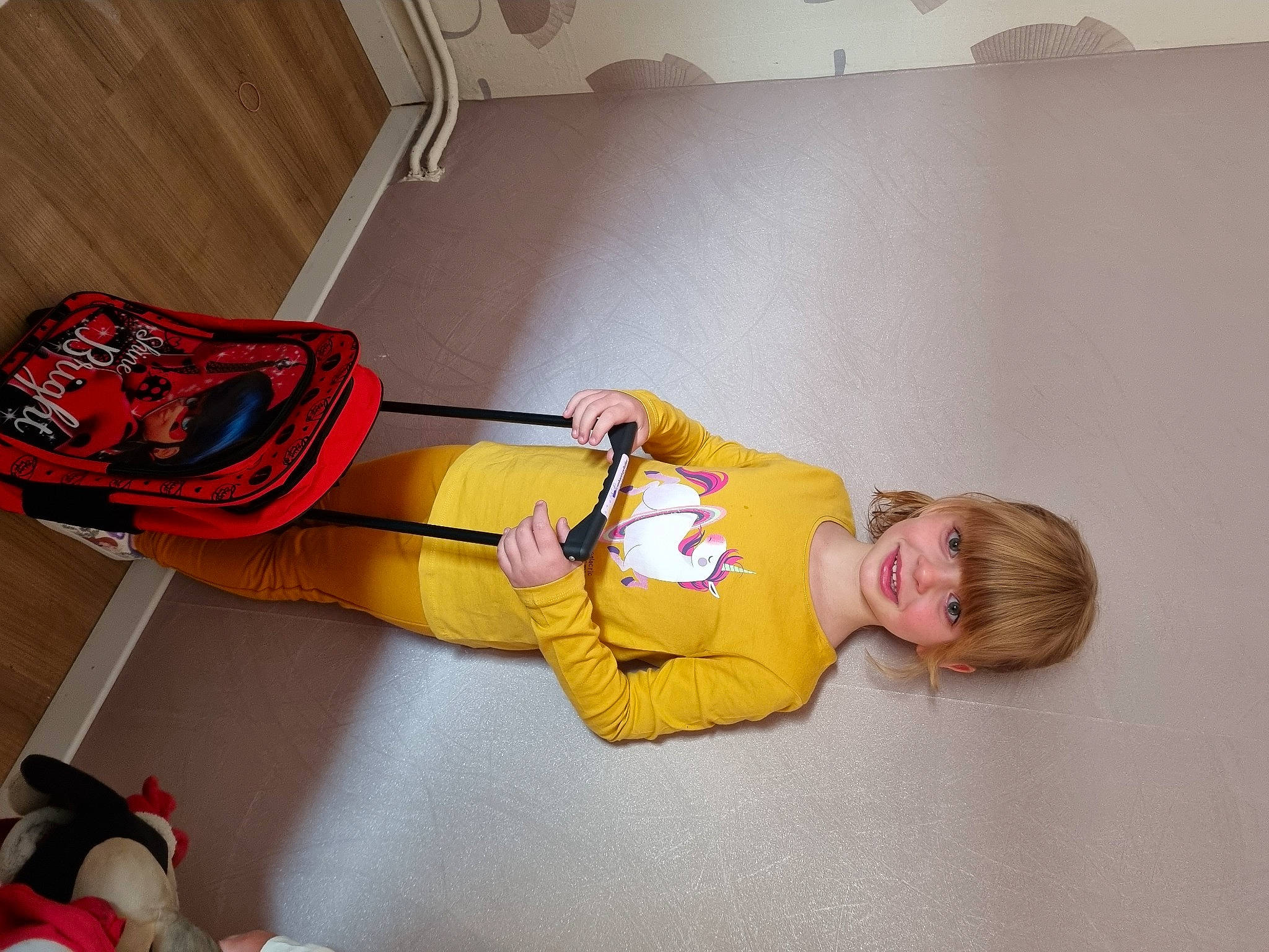 Anaya participe au concours pour gagner de l'argent avec cette photo : baby_toddler_clothing, bag, carmine, child, comfort, couch, flooring, fun, hardwood, human_leg, joy, knee, luggage_and_bags, orange, outdoor_shoe, person, personal_protective_equipment, room, sitting, sportswear